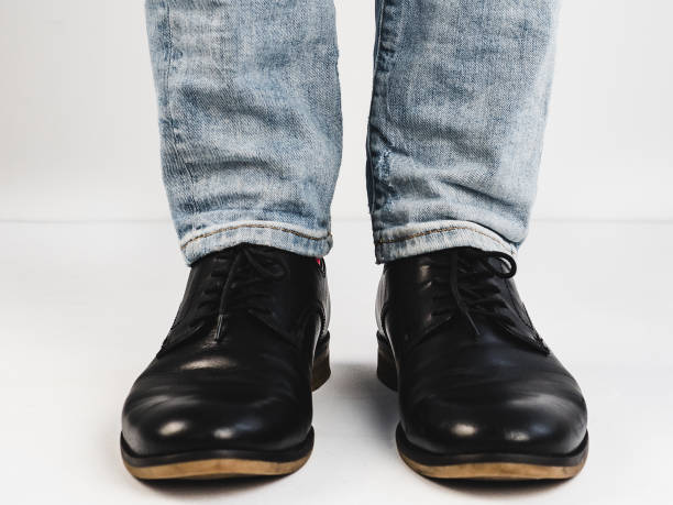 istock Male legs in black shoes 943387970