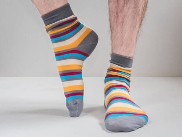 istock Men's feet in funny, colorful socks 943389152