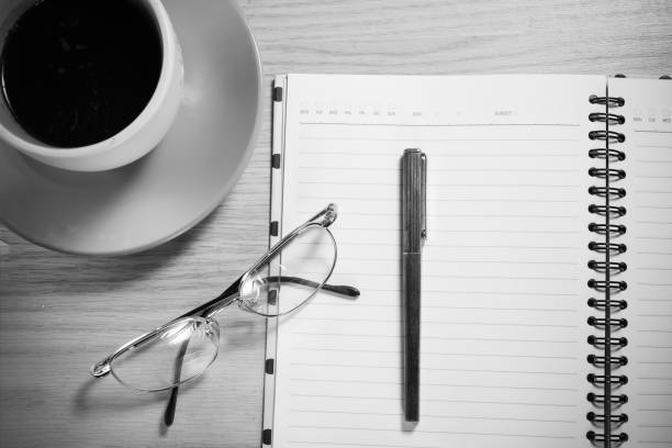 istock Opened notebook with pen ,glasses and coffee on Wooden Background. 943393752