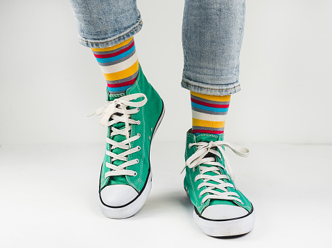 Stylish, bright, green sneakers and funny, happy socks on a white background. Sport, style, beauty, good mood