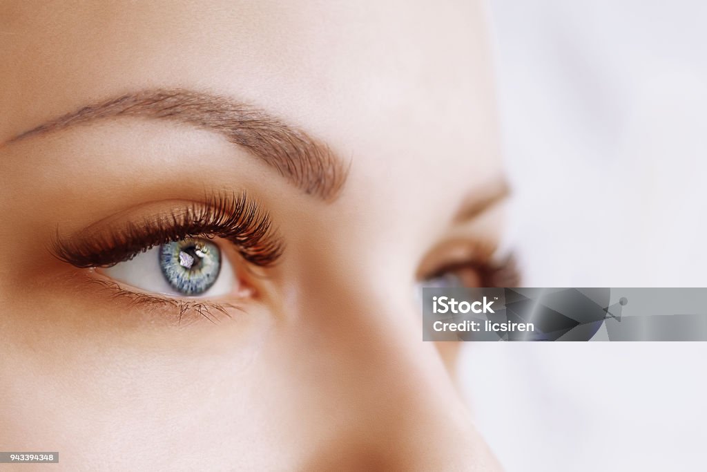 Eyelash Extension Procedure. Woman Eye with Long Eyelashes. Close up, selective focus Eyelash Extension Procedure. Woman Eye with Long Eyelashes. Lashes. Close up, macro, selective focus Eye Stock Photo