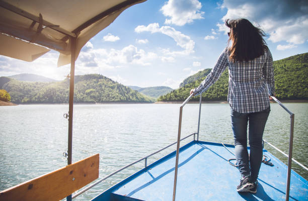 istock woman enjoys a boat ride on river. 943397908