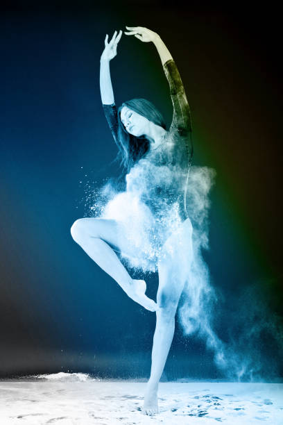 istock Slender blonde dancing in white dust studio shot 943398082