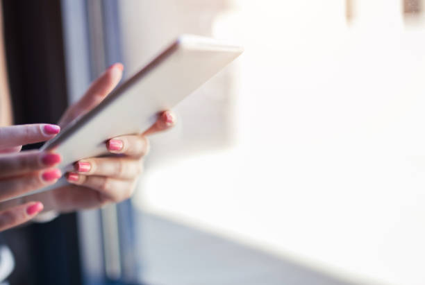 istock Hand of young woman holding tablet. 943404192