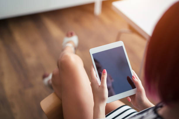 istock Hand of young woman holding tablet. 943404470
