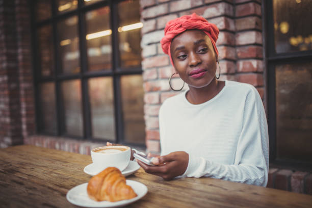 mujer sentada en la cafetería y desayuno - croissant telephone coffee shop on the phone fotografías e imágenes de stock