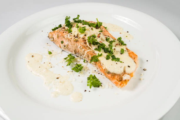 istock Fried Salmon with cheese sauce, parsley and pepper. 943418894
