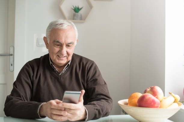 istock Older man looking on mobile phone 943424648