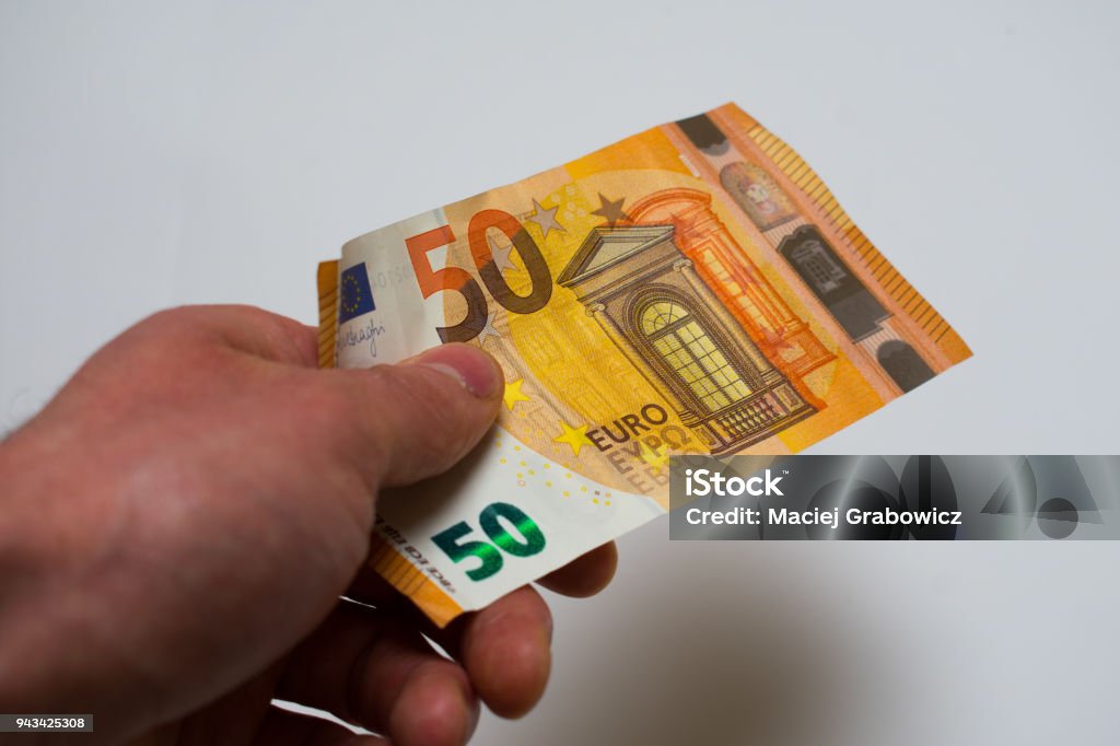 Mano sosteniendo el billete de 50 euros aislado sobre fondo blanco - Foto de stock de 2015 libre de derechos