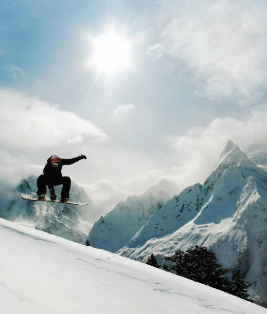 homme sur le snowboard, équitation et saut d’obstacles - faire du snowboard photos et images de collection