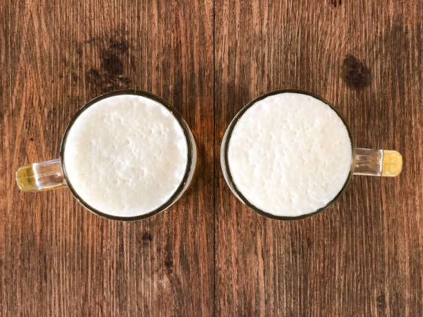Two beer mugs close-up on wooden table