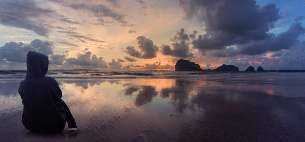 istock woman watching sun on the beach 943441066