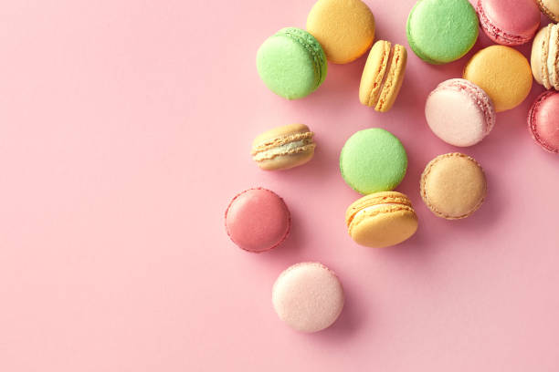 istock Colorful french macarons on pink background 943443612