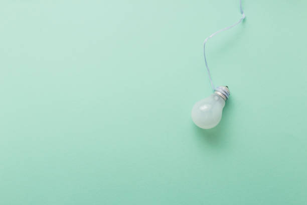 istock Light bulb on pastel green background top view, flat lay with copy space 943449582