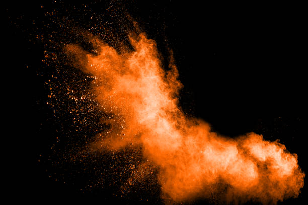 istock abstract orange dust explosion on  black background. abstract orange powder splattered on dark background, Freeze motion of orange powder splash. Painted Holi in festival. 943452626