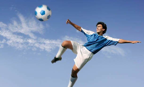 istock Blue sky over soccer player hitting ball 94346215