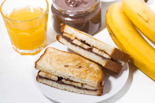 istock sandwich with chocolate paste and banana for breakfast, top view 943465372