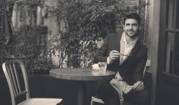 istock Attractive young man sitting in coffee shop and drinking coffee 943474970