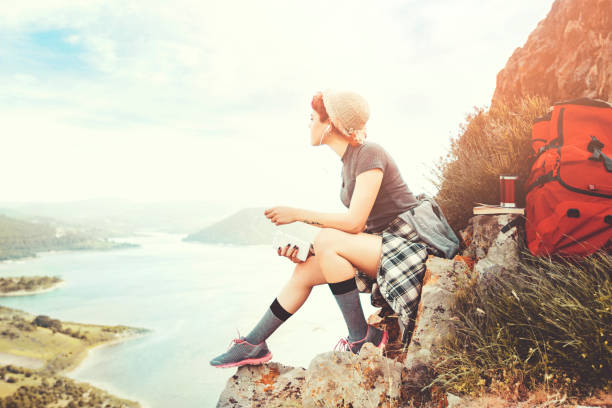 istock Woman Traveler with Backpack relaxing in Mountains 943475766
