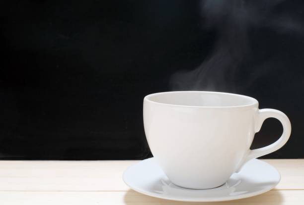 istock hot coffee in white coffee mug on wooden table black background 943478586