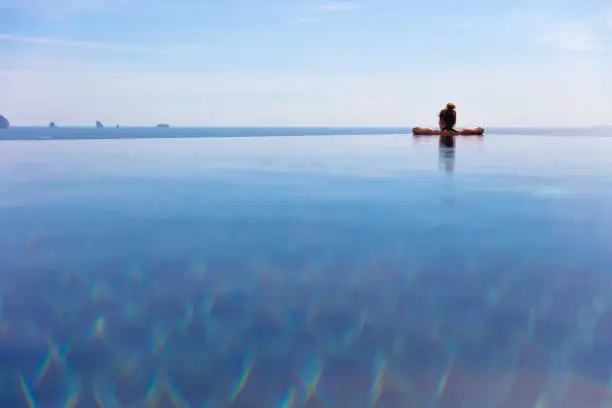 Rear view of woman resting in infinity pool at a Aonang Beach Resort Thailand Asia