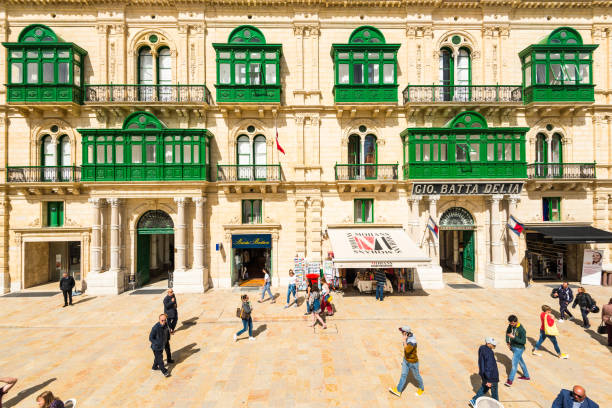 A view of the historic architecture in Valletta, Malta. The image shows closed shops and the Grand Harbour Hotel, capturing the city's unique blend of history and urban life.