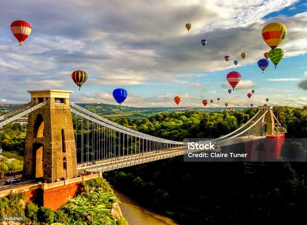 Hot air balloons over suspension bridge in the English countryside Bristol international balloon fiesta is an annual event. The balloons are flying over Clifton suspension bridge. Bristol - England Stock Photo