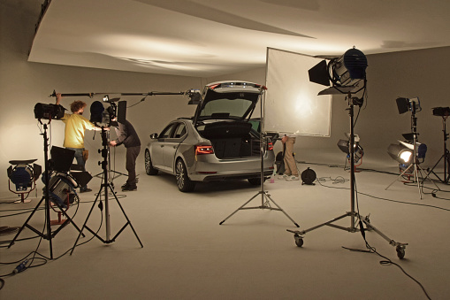 Prague, Czech Republic - 10 February, 2015: Modern car on the professional photo session in photo studio. These workers prepare the car to photos.