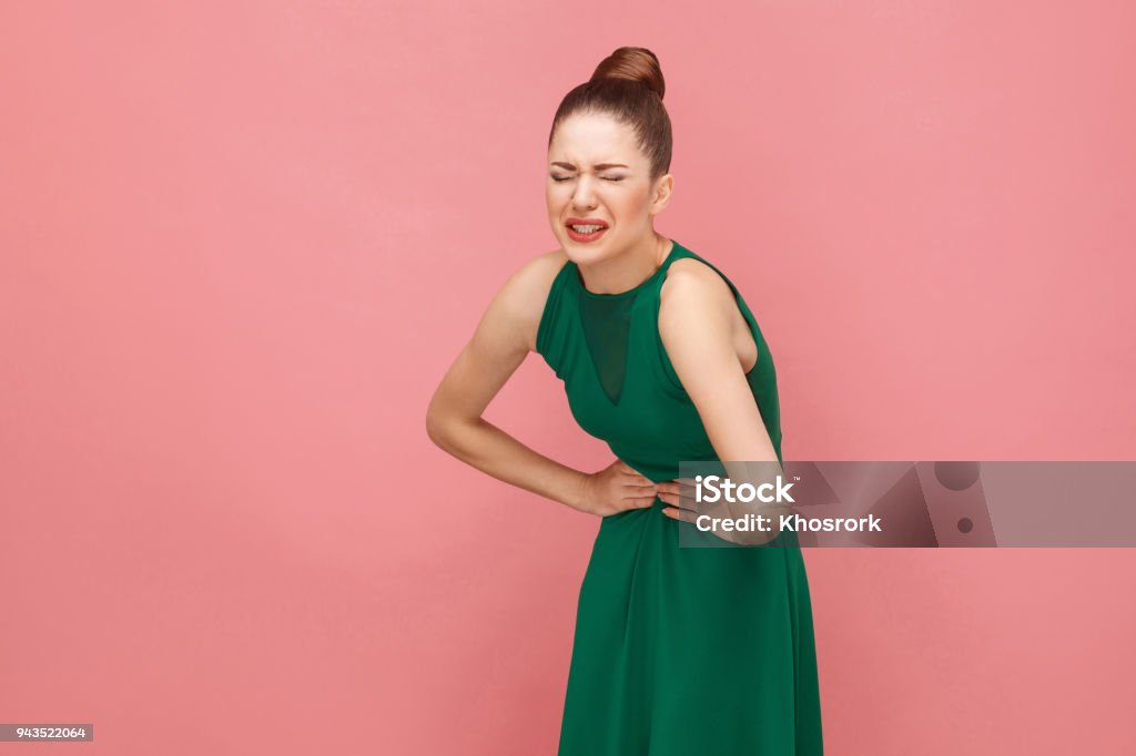 Woamn have stomach pain. Pms or pregnant Woamn have stomach pain. Pms or pregnant. Expression emotion and feelings concept. Studio shot, isolated on pink background Pain Stock Photo