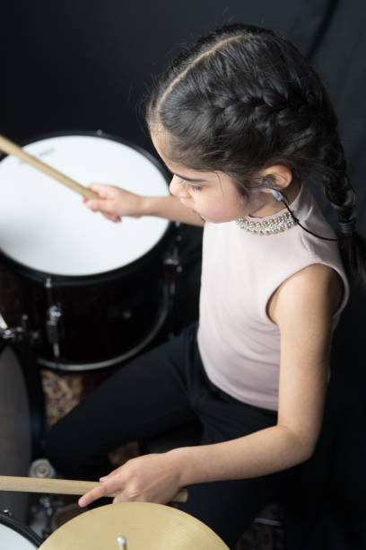 istock 5 year old girl practices the drums 943525356