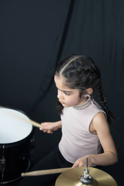 istock 5 year old girl practices the drums 943525392