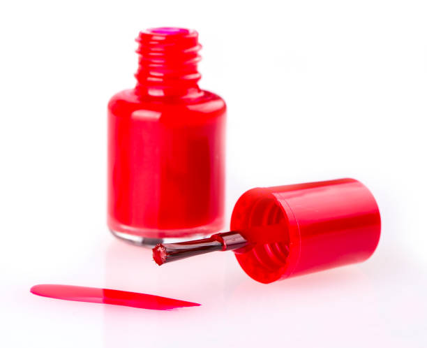 istock close up of  a nail polish bottle and drop on white 943525736