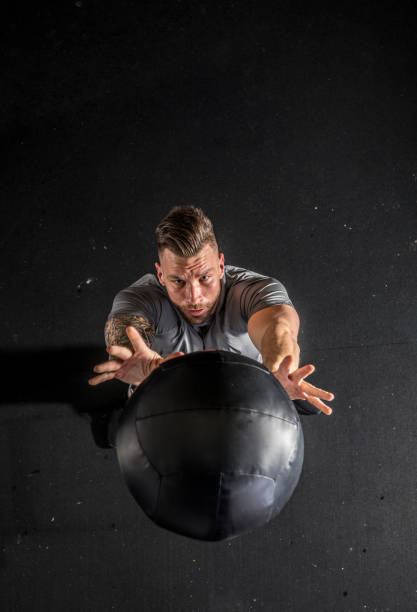 adult man doing strength exercise with medicine ball - single step imagens e fotografias de stock