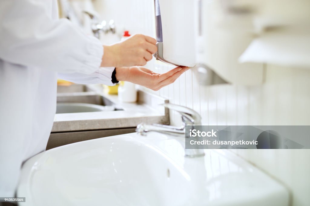 Close up view of a worker in sterile cloths washing hands a bathroom before working. Hygiene Stock Photo