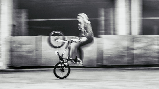 Young woman speeding with bmx bicycle.