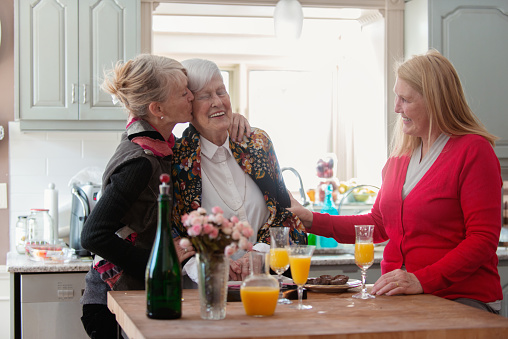 Four generation family take time together for the mother's day. In this photo the mother cheers with their daughter in the kitchen with happiness. Photo was taken in Quebec Canada.