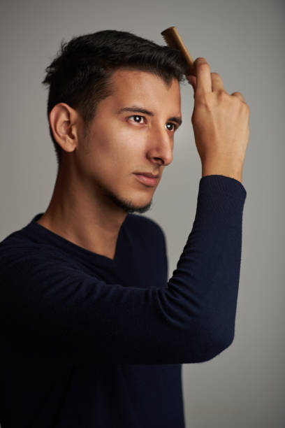 istock Young man grooming his hair 943561026