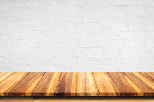 istock Empty top of wooden table on white brick wall background. 943566808