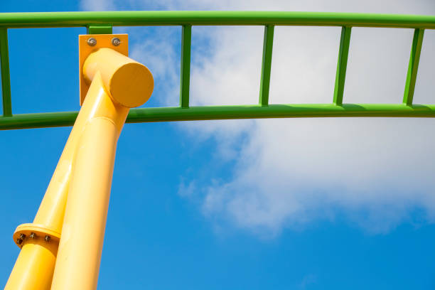 istock yellow and green rollercoaster close up look with blue cloudy sky background 943566838