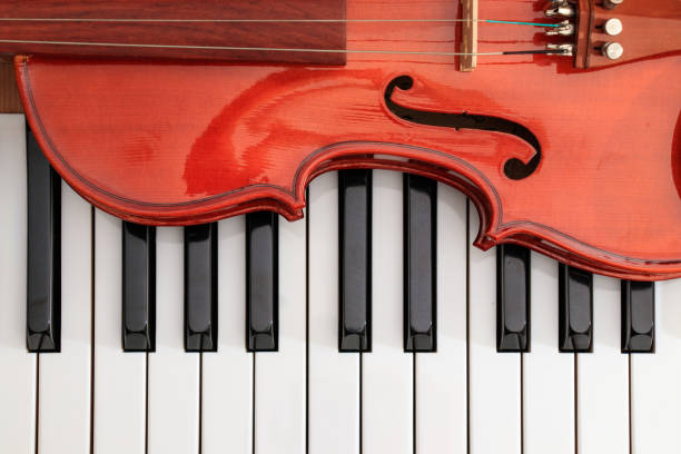 istock classical violin on white and black piano keys close-up background showing strings 943576748