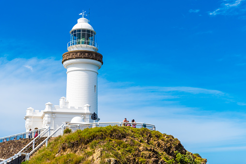 Byron Bay, NSW, Australia- January 3, 2018: Ocean view over Cape Byron lighthouse, the Most Easterly Point on the Australian Mainland in Byron Bay, Australia. Unidentified tourists in the background.