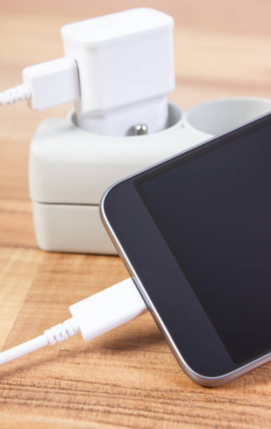 Mobile phone with connected plug of charger, smartphone charging concept