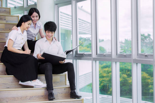 タ�イの大学でアジアの学生のグループで坐り、緩むライブラリ - collegian ストックフォトと画像