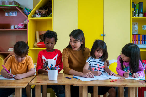 asian teacher and student in an international preschool study art subject togather - togather imagens e fotografias de stock