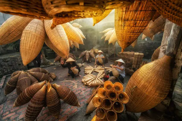 Photo of Group of Old Vietnamese female craftsman making the traditional bamboo fish trap or weave at the old traditional house in Thu sy trade village, Hung Yen, Vietnam, traditional artist concept