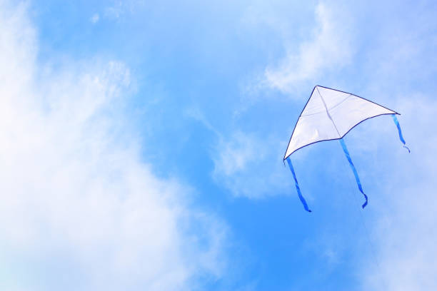istock Colorful kite flying in the blue sky through the clouds 943601504
