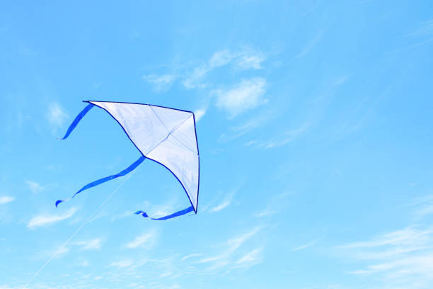 istock Colorful kite flying in the blue sky through the clouds 943601562