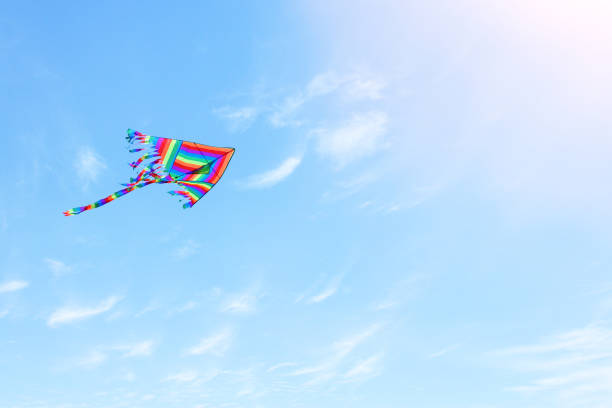 istock Colorful kite flying in the blue sky through the clouds 943601592