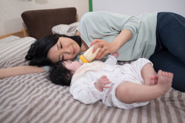 Mother feeding baby with milk Everyday life of  Japanese baby and mother joined at hip stock pictures, royalty-free photos & images