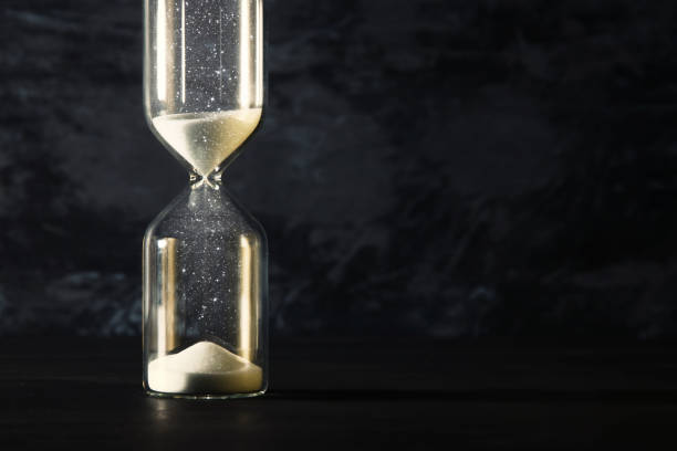 istock Image of hourglass as time passing concept over black background for business deadline. Glitter overlay. 943609632